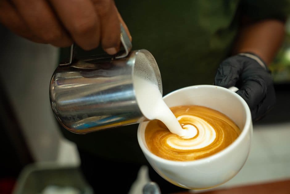 A barista pouring latte art